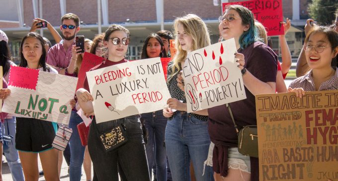 Demonstrators hold signs and posters in support of the PERIOD Denton rally at Dallas City Hall on Oct. 19, 2019. Image by Quincy Palmer
